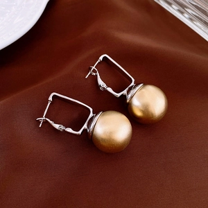 Detailed macro of S925 silver needle square hoop earrings with golden pearl pendants