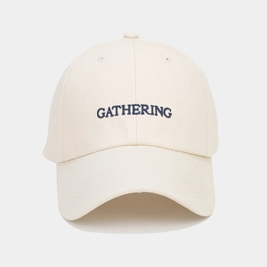 Détail de la broderie GATHERING sur casquette de baseball blanc cassé en sergé