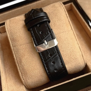 Detail of black leather watch strap with silver buckle in a premium gift box case