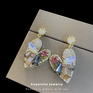 Exquisite gold heart drop earrings with colorful crystals and pearl accents on jewelry box