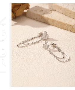 Detail of s925 silver heart earrings with sparkling zircons and long tassel chains