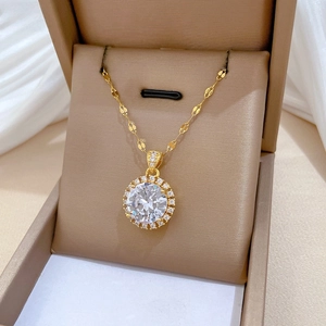 Detail of a gold titanium necklace with a large round cubic zirconia halo pendant