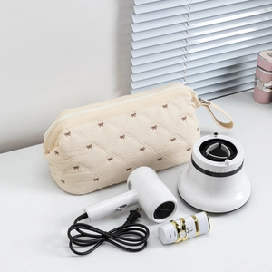 Quilted beige hair dryer storage bag with bow embroidery and convenient carry handle