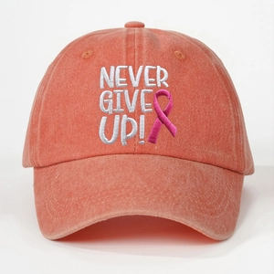 Detailed embroidery of 'NEVER GIVE UP' and pink ribbon on washed cotton baseball cap