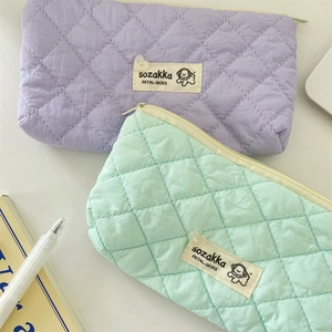 Macro detail of quilted macaron stationery bags in lavender and mint green nylon fabric