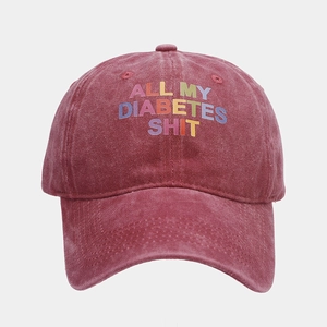 Detail of vintage washed burgundy baseball cap with gradient letter print on cotton fabric