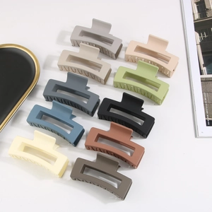 Detail of ten large matte rectangular hair claws in various Morandi colors on a tray