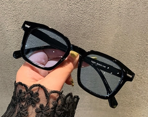 Close-up of black square sunglasses with light blue lenses showing 73351 size specs