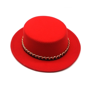 Detail of red boater hat with gold chain band and soft wool felt texture closeup