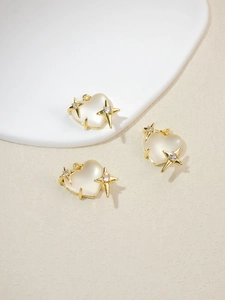 Three heart-shaped gold pendants with milky opal stones and sparkling star accents