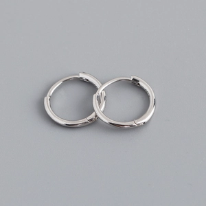 Close-up of minimalist silver hoop earrings featuring S925 hallmark on the inner band