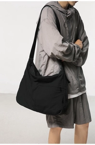 Detail showing the durable nylon fabric and hidden zipper pocket of the black crossbody bag