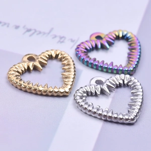 Macro view of gold, silver, and rainbow heart pendants with textured edges for DIY necklaces