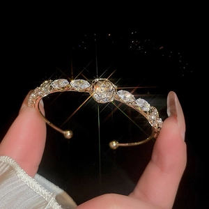 Macro detail of 14k gold plated bangle with marquise cut cubic zirconia flower design