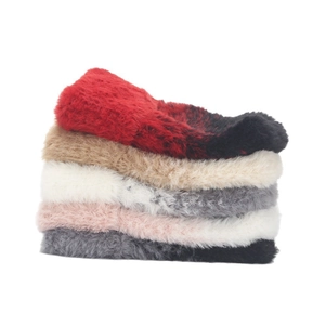 Close-up of soft faux fur headbands stacked in multiple colors including red and pink