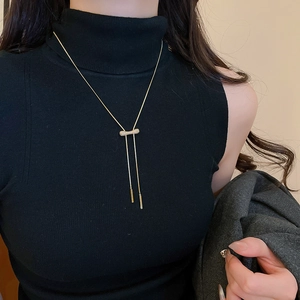 Détail du collier plaqué or 18 carats avec pompons en zircon étincelant sur tricot noir