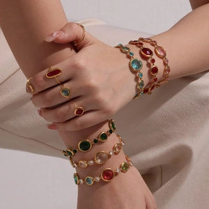 Elegant gold bracelet stack with multi-colored crystals on a female model's wrist