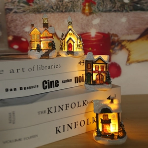 Detailed view of glowing miniature Christmas houses with warm LED light on books