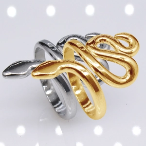 Macro shot of intertwining gold and silver snake rings with polished metallic finish