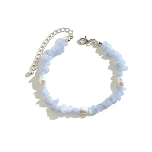 Irregular turquoise and pearl beaded bracelet with silver lobster clasp on white background