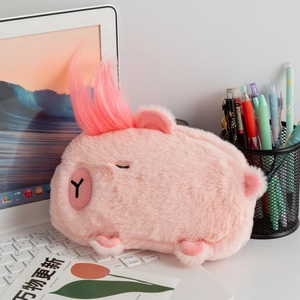Pink Capybara plush pencil case with long faux hair detail on a laptop keyboard