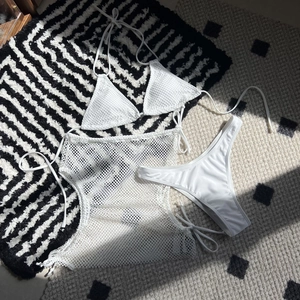 Close-up of white mesh drawstring three-piece bikini set with sheer texture detail
