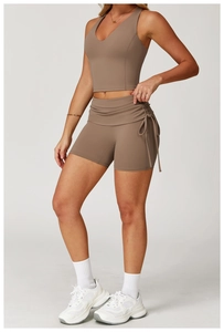 Detail of high-waisted yoga shorts with adjustable side drawstrings in deep mocha brown