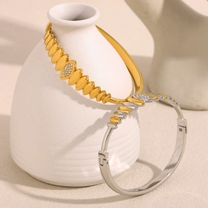 Macro detail of tear-drop link bracelets in gold and silver finish with crystal inlay