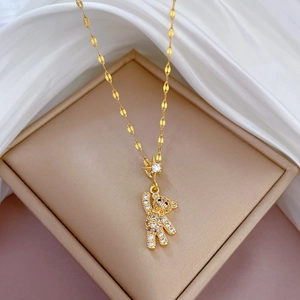 Titanium steel gold necklace with a sparkling crystal bear pendant on white silk