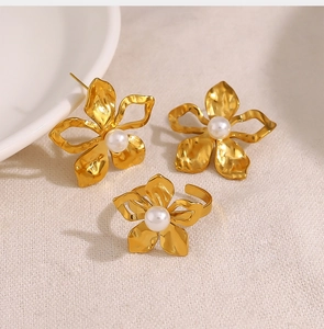 Detail view of 18K gold floral jewelry set with matte finish and white pearls