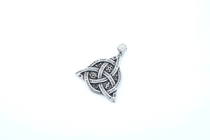 Dettaglio di un ciondolo vichingo vintage con nodo a triangolo e incisioni su argento