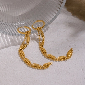 Detail of gold fringe earrings with micro-textured oval links and bead accents