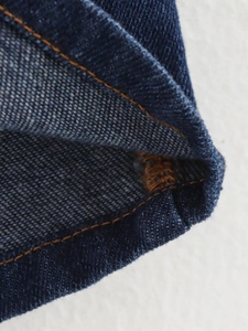 Gros plan sur le denim bleu foncé avec coutures doubles orange de haute qualité