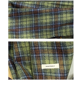Macro detail of vintage green plaid scarf fabric with woven vegetable label
