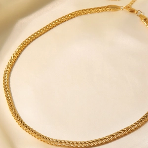 Minimalist 18K gold-plated stainless steel braided twisted necklace on beige silk