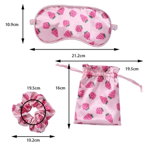 Three-piece pink silk sleep set with strawberry print including eye mask and scrunchie