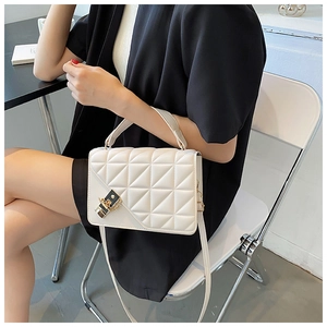 Vue détaillée d'un sac à bandoulière matelassé blanc avec fermoir en métal et poignée
