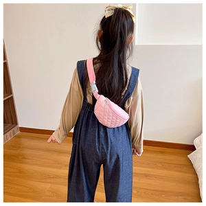 Pink quilted crossbody waist bag for kids shown on a model for scale and fit