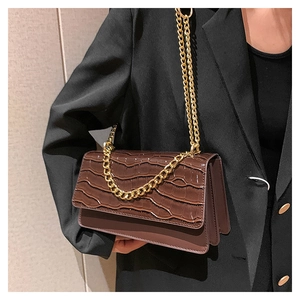 Détail du sac à main marron foncé à motif crocodile avec chaîne dorée et triple épaisseur
