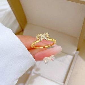 Close-up of gold adjustable ring with intricate carving and inlaid small diamonds