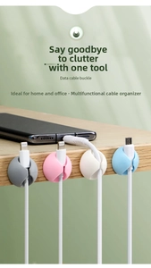 Detail of multi-color silicone cable clips organizing wires on a wooden desk edge