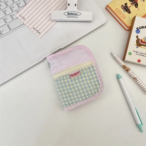 Close-up of heart-quilted fabric organizer pouch with pastel stripes and zipper detail