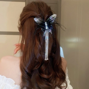 Detail of black mesh bow hair clip with long sparkling rhinestone tassels on model