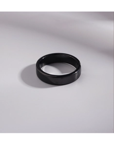 Top-down view of a minimalist black polished ring with a glossy reflective surface