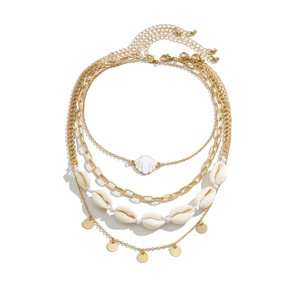 Close-up of bohemian layered gold necklace with shell beads and starfish pendant charms