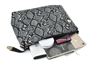 Macro view of snakeskin pattern pouch showing interior space for phone and makeup