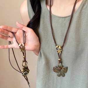 Vintage bohemian necklace with butterfly and camera pendants on wood bead wax cord