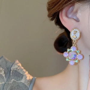 Gros plan de boucles d'oreilles camée vintage avec croix en cristal sur l'oreille