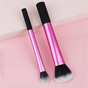 Detailed close-up of pink and black makeup brushes with soft gradient fiber bristles