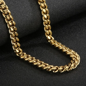 Macro shot of heavy gold Cuban link chain with polished finish on a textured black surface